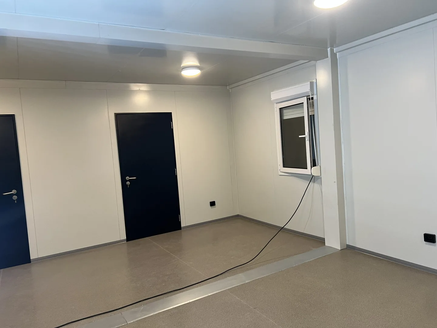 Ferdig monterte moduler inne i hangaren — kontor og klasserom på rekke
