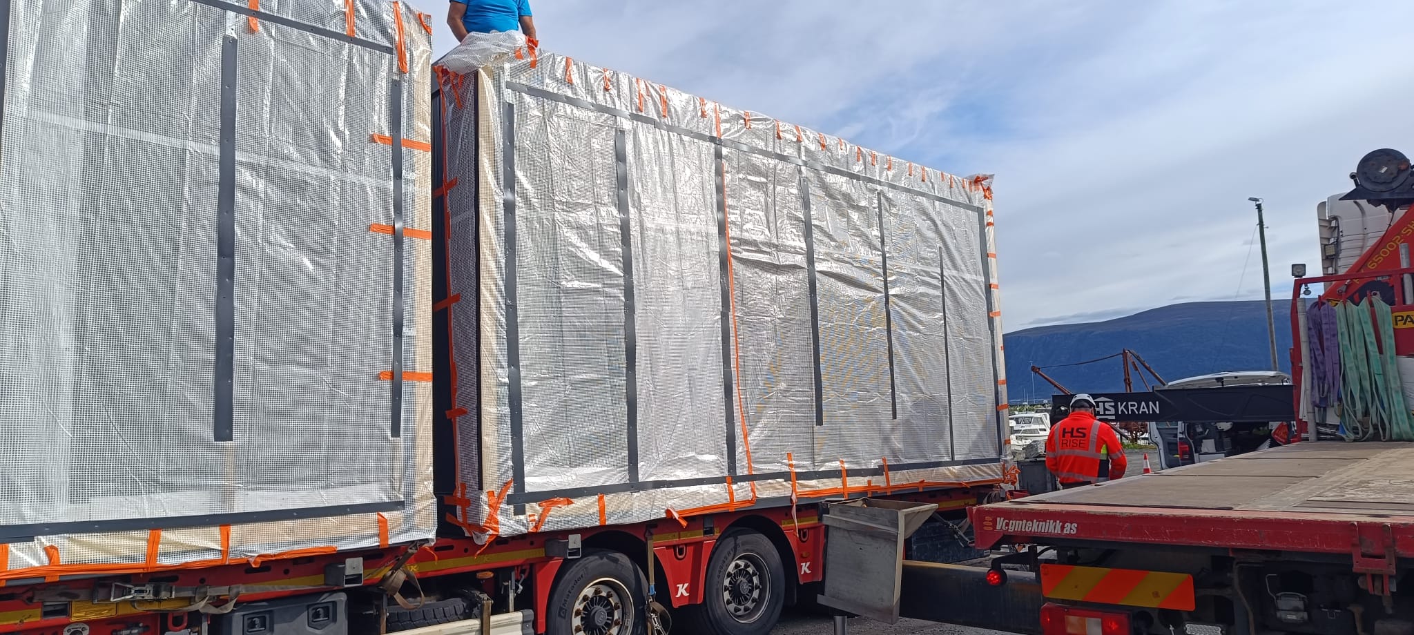 Innpakkede moduler losses med kran fra trailer på leveringsstedet i Norge