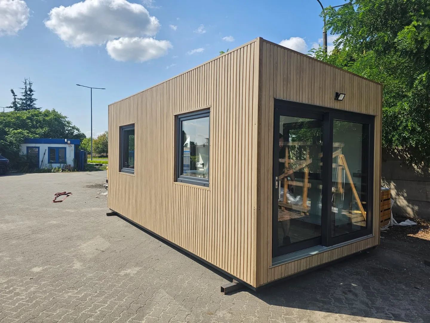 Premium modul med vertikal trekledning, skyvedør i glass og store vinduer